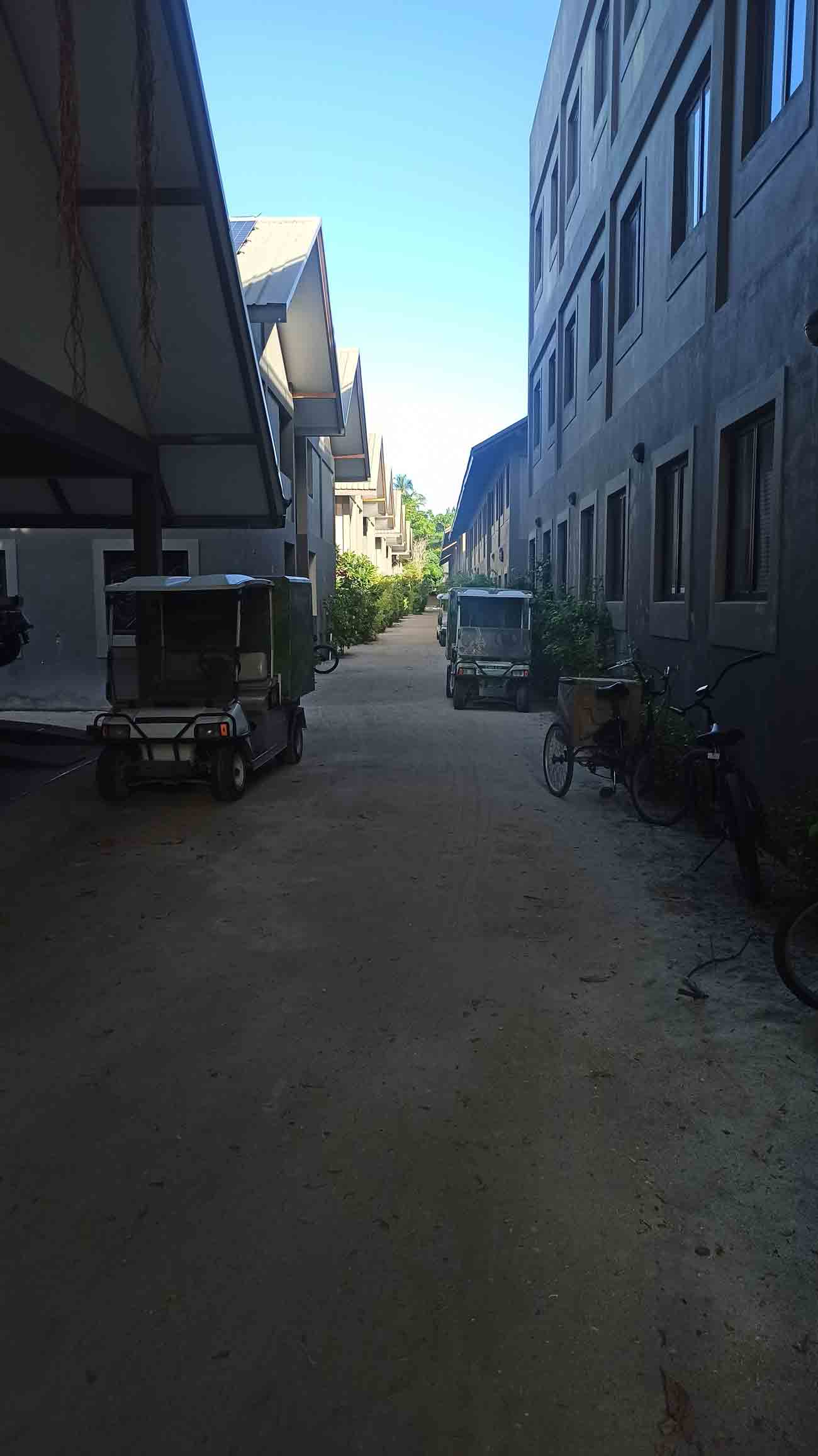 sandy road surrounded by buildings on a resort in Maldives