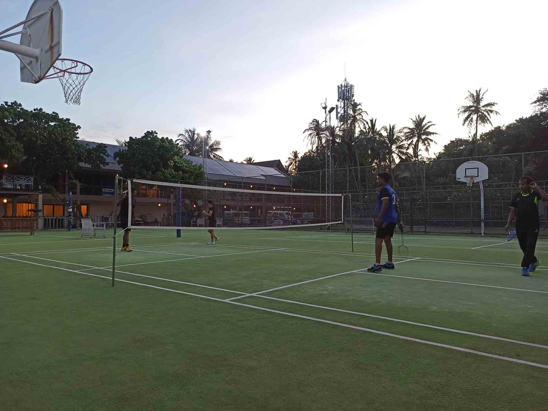 Il personale gioca a badminton al tramonto dopo il lavoro.